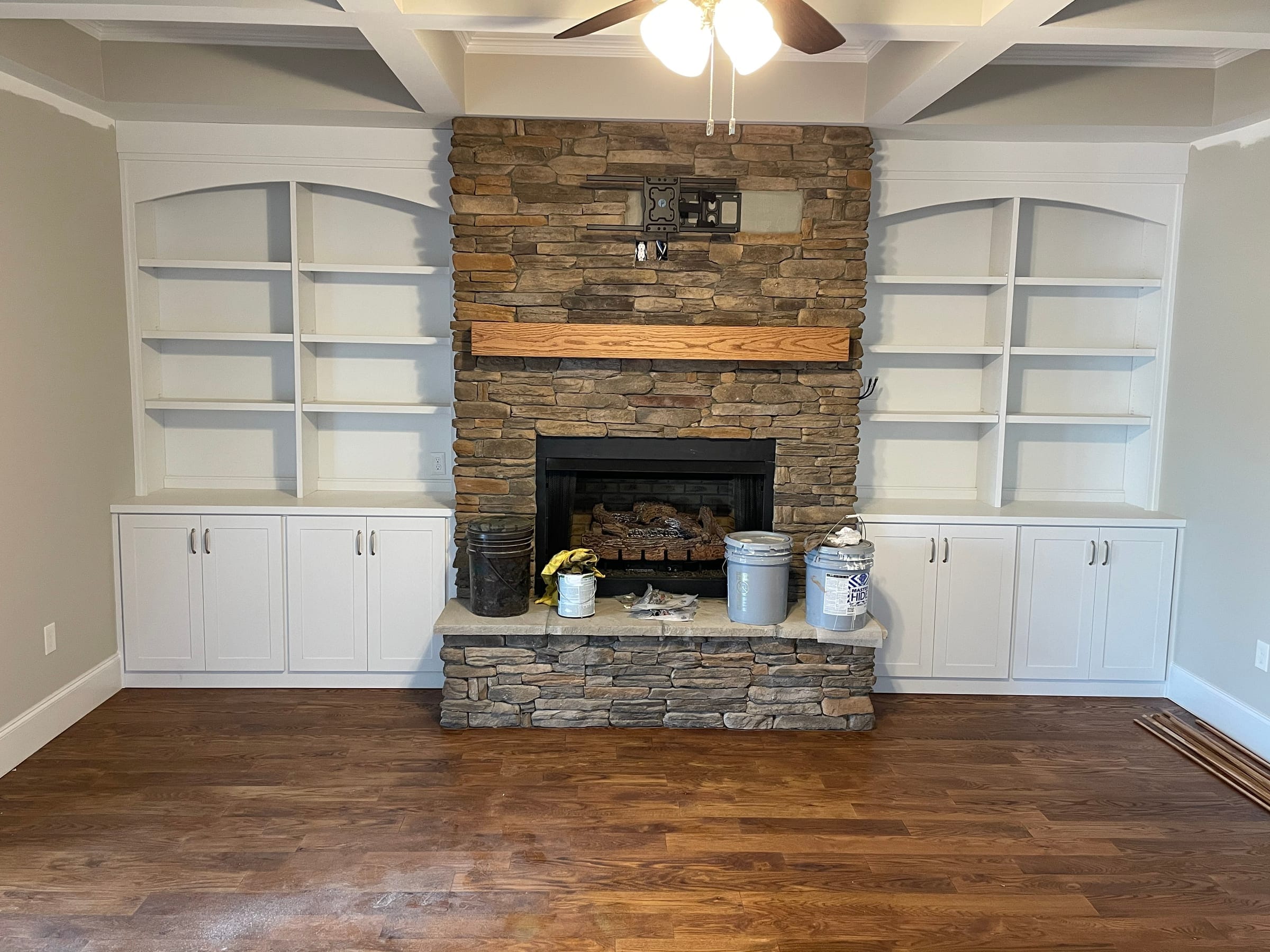 Painted built-in bookcases flanking a stone fireplace