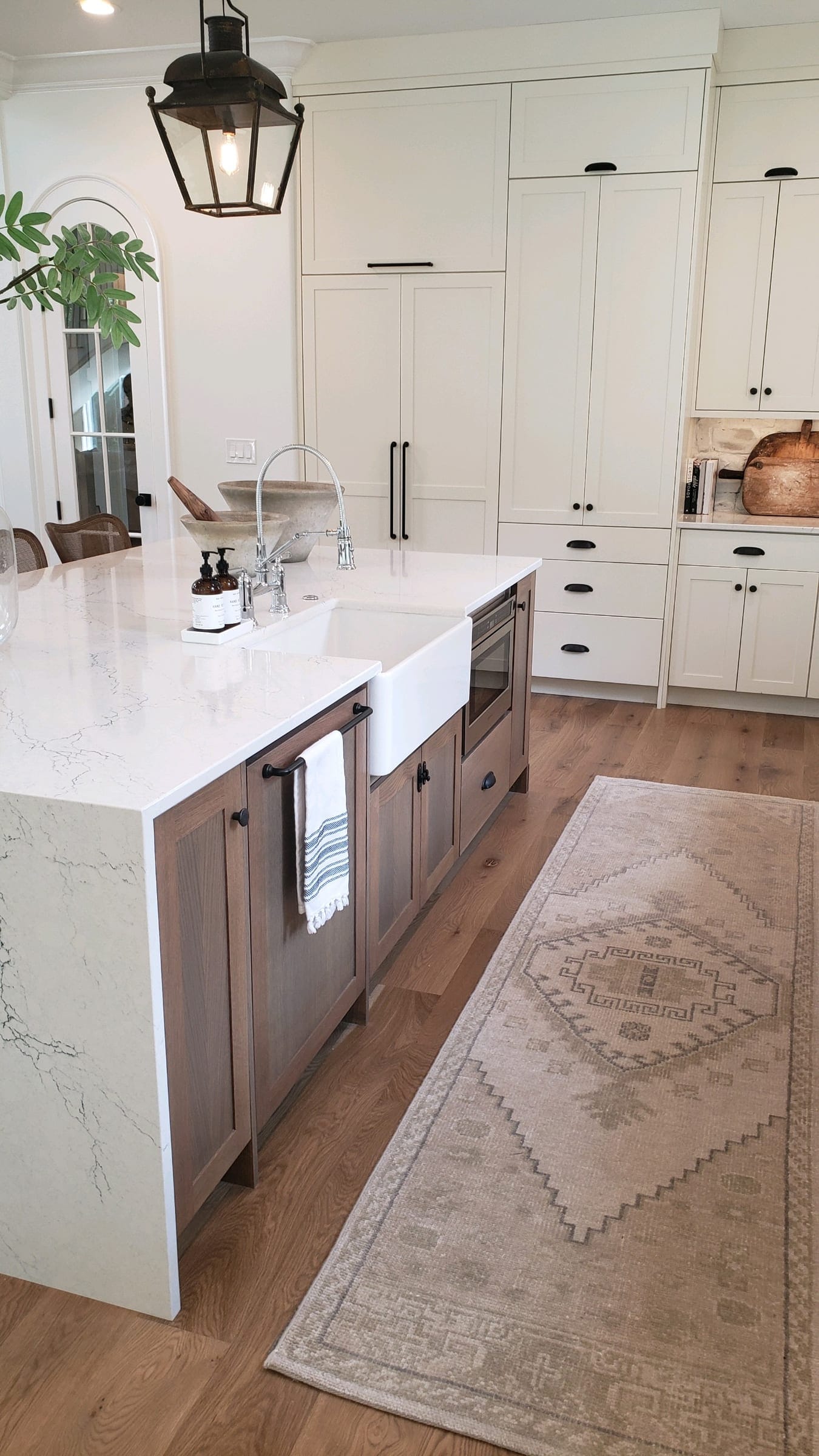 Waterfall island with a farmhouse sink and stained base